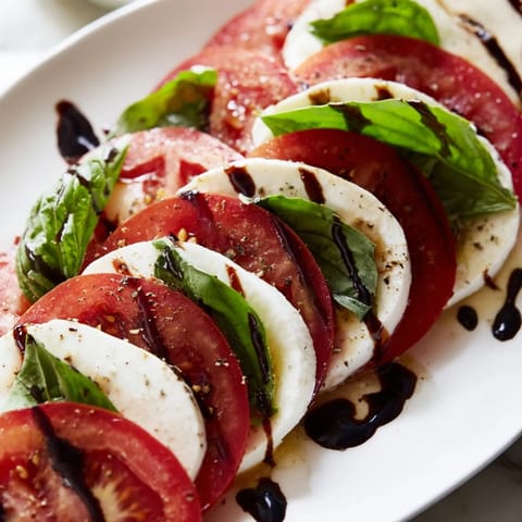 A visually appealing Caprese Salad with basil leaves, ready to enjoy as a light and flavorful starter.
