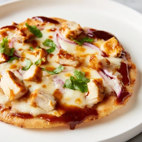 Sizzling BBQ Chicken Flatbread fresh from the oven with red onion and fresh cilantro garnish.  