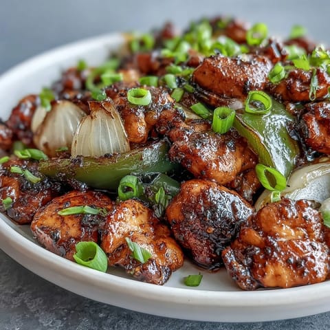 Black pepper chicken served hot over a bowl of fluffy steamed white rice.