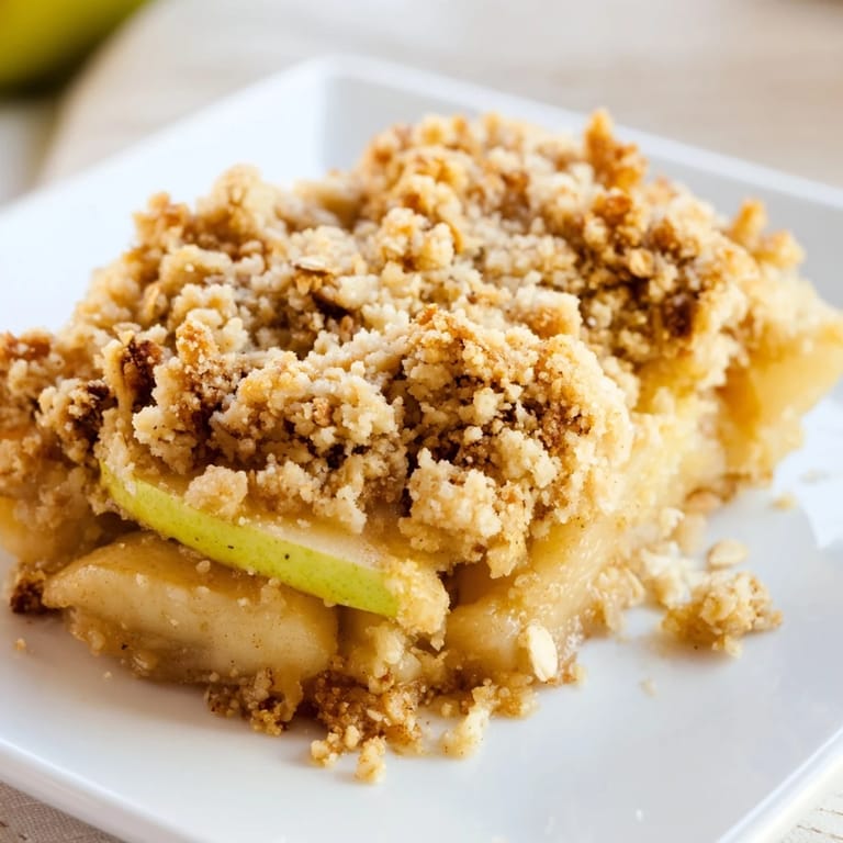 Enjoy a slice of homemade apple crumble, fragrant with cinnamon and ready to serve warm.