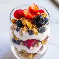 Beautiful layered berry parfait with creamy yogurt, crunchy granola, and vibrant fresh berries.
