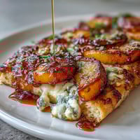 Grilled flatbread topped with sweet peaches, melted Brie, and BBQ sauce, finished with fresh basil.  